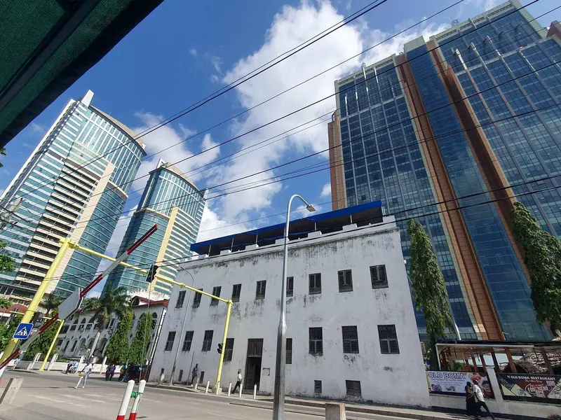 Colonial-era building in front of modern towers, central Dar es Salaam